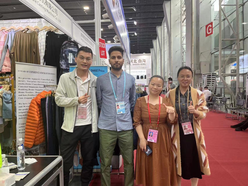 BENTA Dongguan knit supplier taking group photos with international clients at Canton Fair