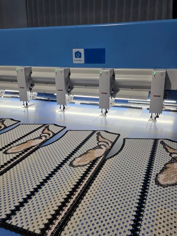 MAYA multi-head automatic embroidery machine inside BENTA factory, producing grid hollow crochet vest fabric panels decorated with animal embroidery motifs for OEM custom knitwear.