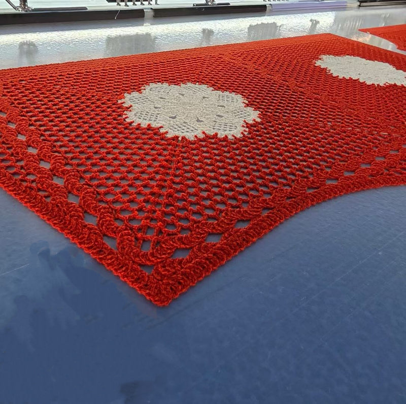 Close-up of red hollow crochet lace fabric with white floral motifs produced at BENTA factory, handmade style crochet textile for OEM apparel & home textile