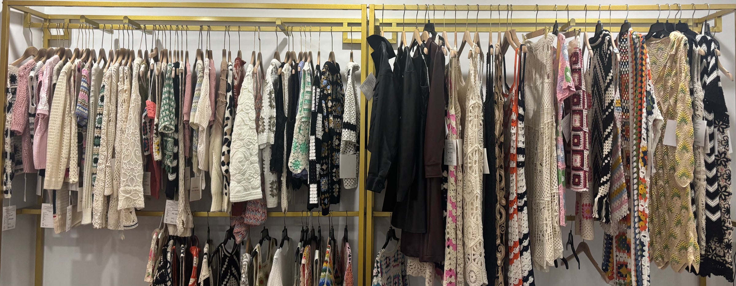 BENTA sample showroom display rack, various handmade crochet knitwear garments collection, OEM knit clothing samples.